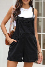 Woman wearing square neck denim overalls with pockets styled with a white tank top and accessories.