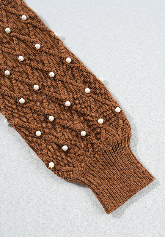 Bella Road sweater sleeve with pearl details and diamond knit pattern, featuring a ribbed cuff in rich brown color.