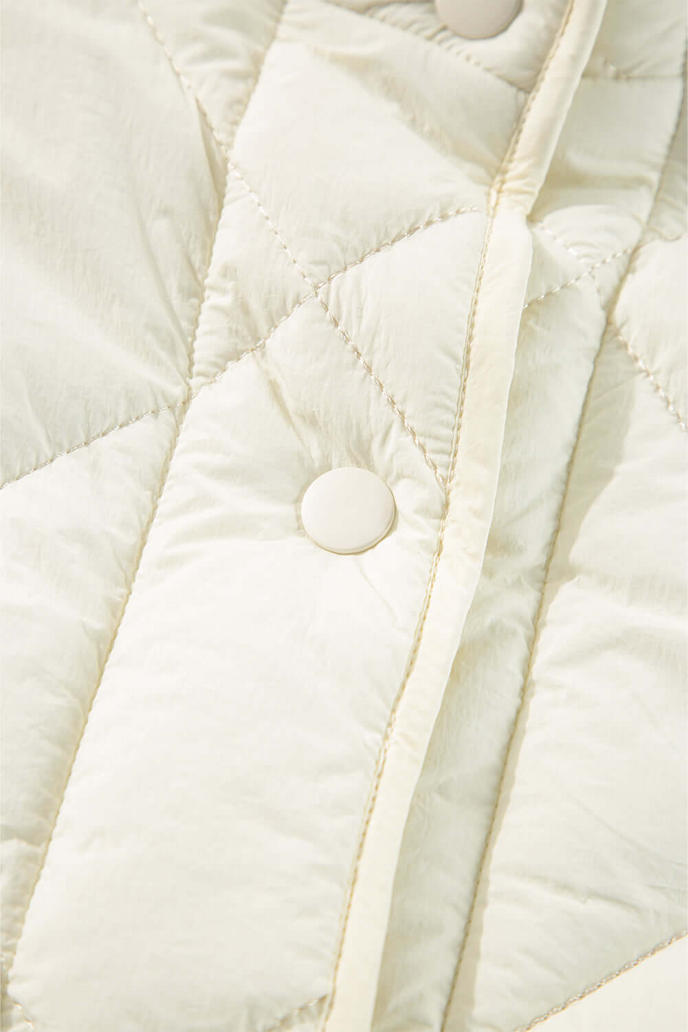 Close-up of ivory Bella Road Snap Down Texture Vest Coat with snap detail and quilted design.