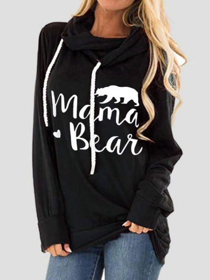 Woman wearing a black hoodie with white drawstring and "Mama Bear" letter graphic design.