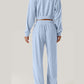 Back view of Bella Road Crisscross Round Neck Top and Drawstring Pants Set in light blue, showcasing the full outfit from behind.