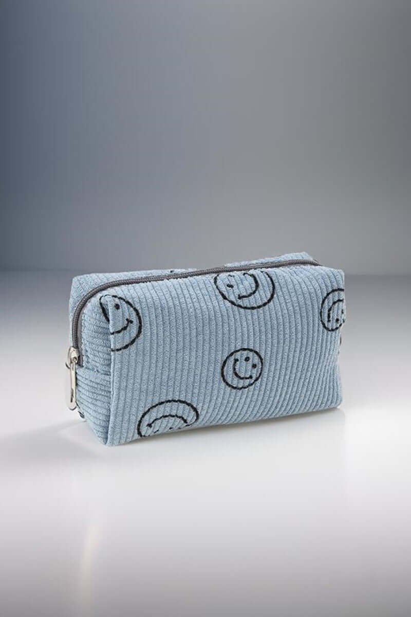 Small blue corduroy cosmetic pouch with cheerful embroidered smiley faces, perfect for makeup organization on-the-go.