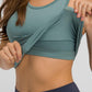 Woman demonstrating the removable padding of a teal Millennia Round Neck Racerback Active Tank for workouts.