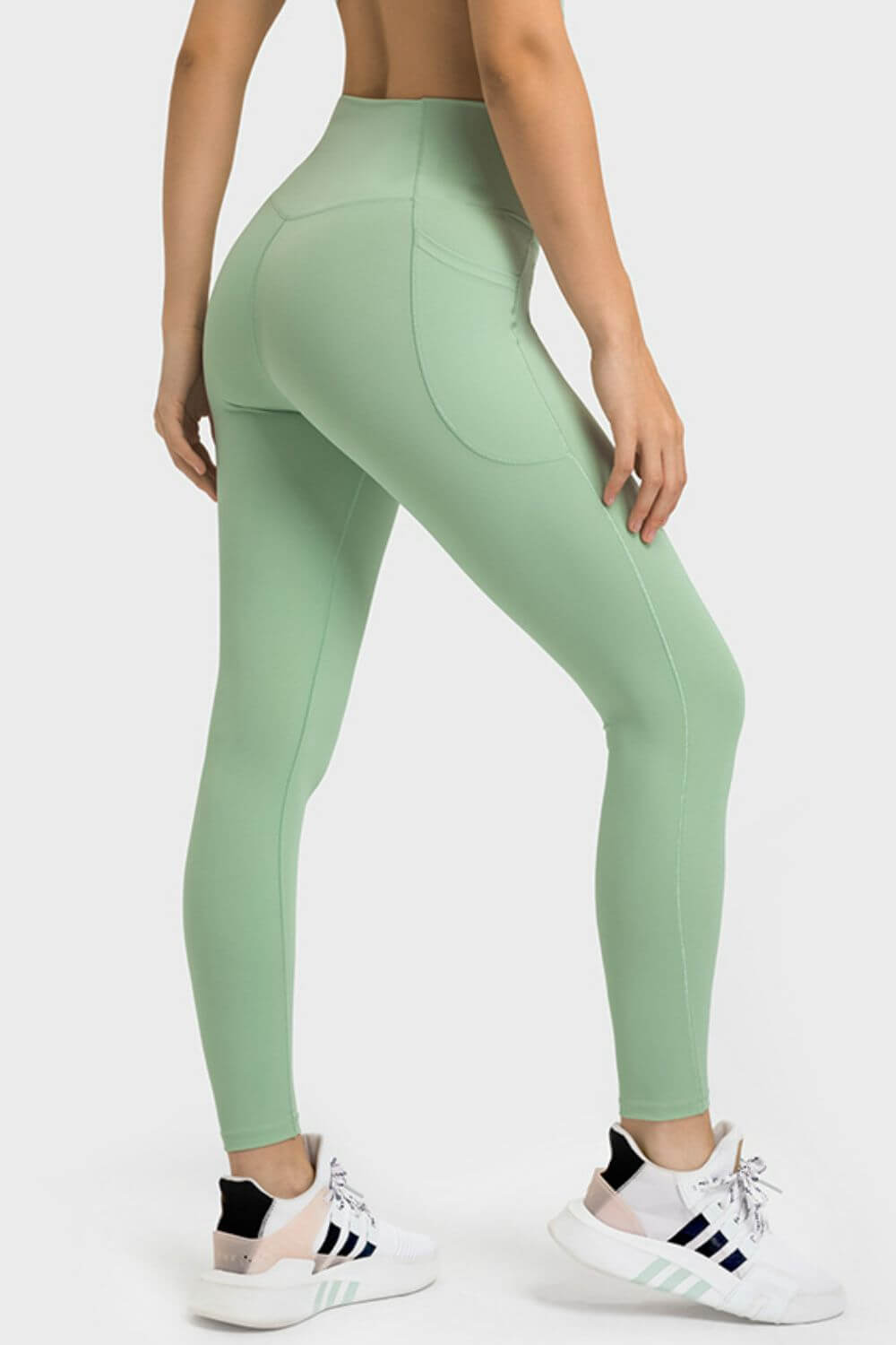 Millennia V-Waist Yoga Leggings in soft green, showcasing a flattering fit and pockets, ideal for yoga and workouts.