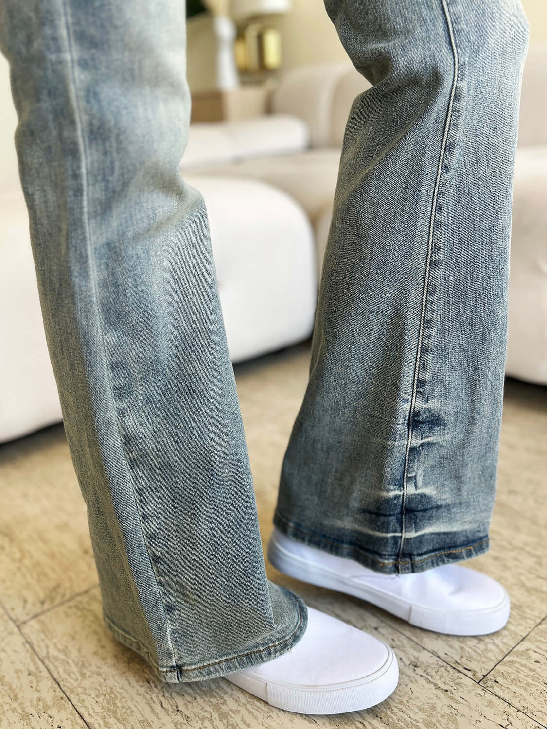 Close-up of woman wearing high waist flare jeans with white sneakers, showcasing Judy Blue Jeans retro style and comfortable denim fabric.