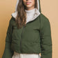 Woman modeling Love Tree Zip Up Cropped Hooded Sherpa Reversible Jacket in green, showcasing cozy and stylish winter fashion.