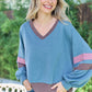 Woman wearing Hailey & Co Color Block V-Neck Cropped Sweatshirt with jeans, showcasing trendy and sporty style.