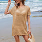 Woman in a sheer openwork cover-up and hat, enjoying a beach day with ocean waves in the background. Perfect summer style!