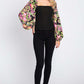 Woman wearing Floral Balloon Sleeve Blouse in black with colorful floral print, standing against a white background.