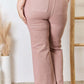 Rear view of model wearing Risen Jeans High Rise Ankle Flare Jeans in pink, showcasing pocketed design and ankle flare style.