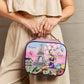 Woman holding Nicole Lee USA printed handbag with Paris design featuring Eiffel Tower and hot air balloons. Stylish pebbled leather accessory.