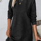 Woman wearing a Bella Road textured round neck long sleeve mini dress in black, styled with necklaces and holding a cup.