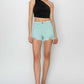 Mid waist frayed hem denim shorts by Risen Jeans styled with a chic black one-shoulder top, showcasing a casual summer look.