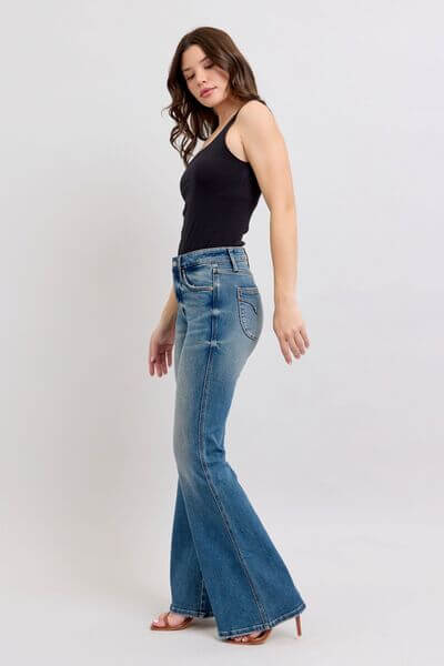 Woman in black tank top wearing Judy Blue tummy control vintage wash jeans, showcasing a chic side view in a stylish pose.