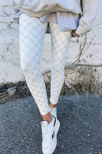 Bella Road Checkered Elastic Waist Leggings in white, worn casually with sneakers against a textured wall background.