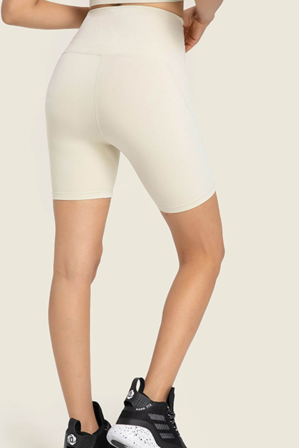 Model showcasing Millennia Seamless High-Rise Wide Waistband Biker Shorts in light color, perfect for comfort and style.