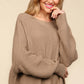 Woman wearing a Haptics Full Size Side Slit Texture Asymmetric Sweater with round neck and long sleeves, showcasing the cozy knit fabric.