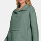 Stylish woman wearing a green Zenana Turtleneck Half Snap Fleece Sweatshirt, showcasing cozy comfort and sporty style.