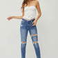 Woman wearing Distressed Frayed Hem Slim Jeans by Risen Jeans, showcasing trendy ripped details and a flattering slim fit.