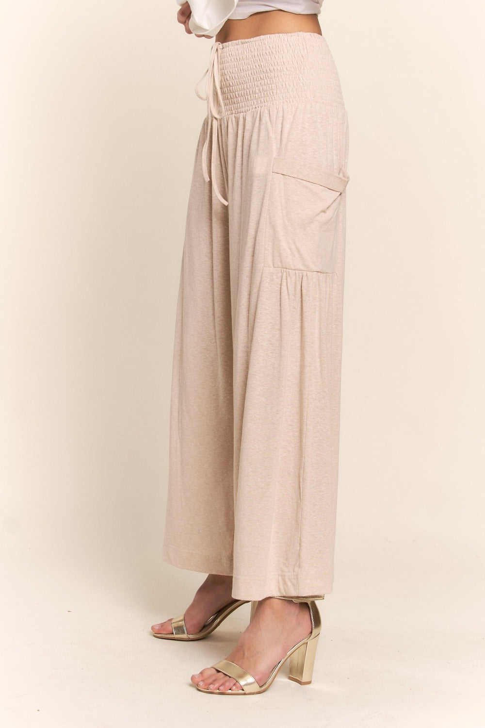 Beige smocked waist boho wide leg pants with pockets, showcasing relaxed fit and style for casual or dressy occasions.