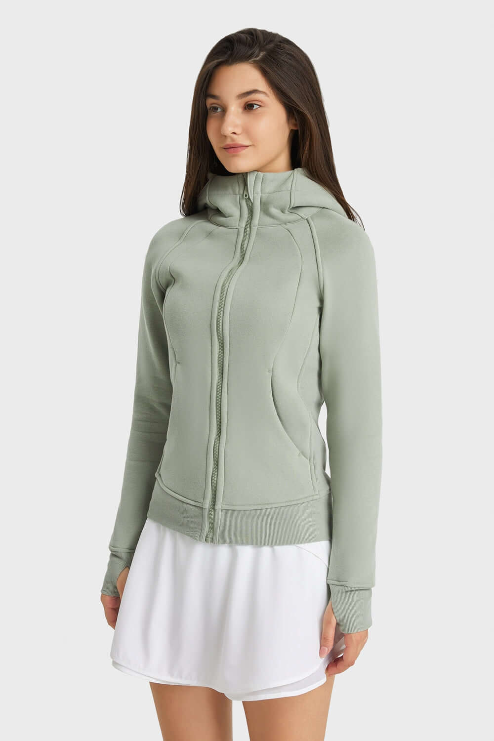 Woman wearing a light green Millennia Zip Up Seam Detail Hooded Sports Jacket, ready for outdoor activities.