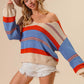 Woman wearing BiBi Multi Color Stripe Scoop Neck Sweater paired with white shorts and a beige hat.