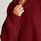 Woman wearing a cozy maroon Double Take Side Slit Round Neck Long Sleeve Sweater with ribbed texture