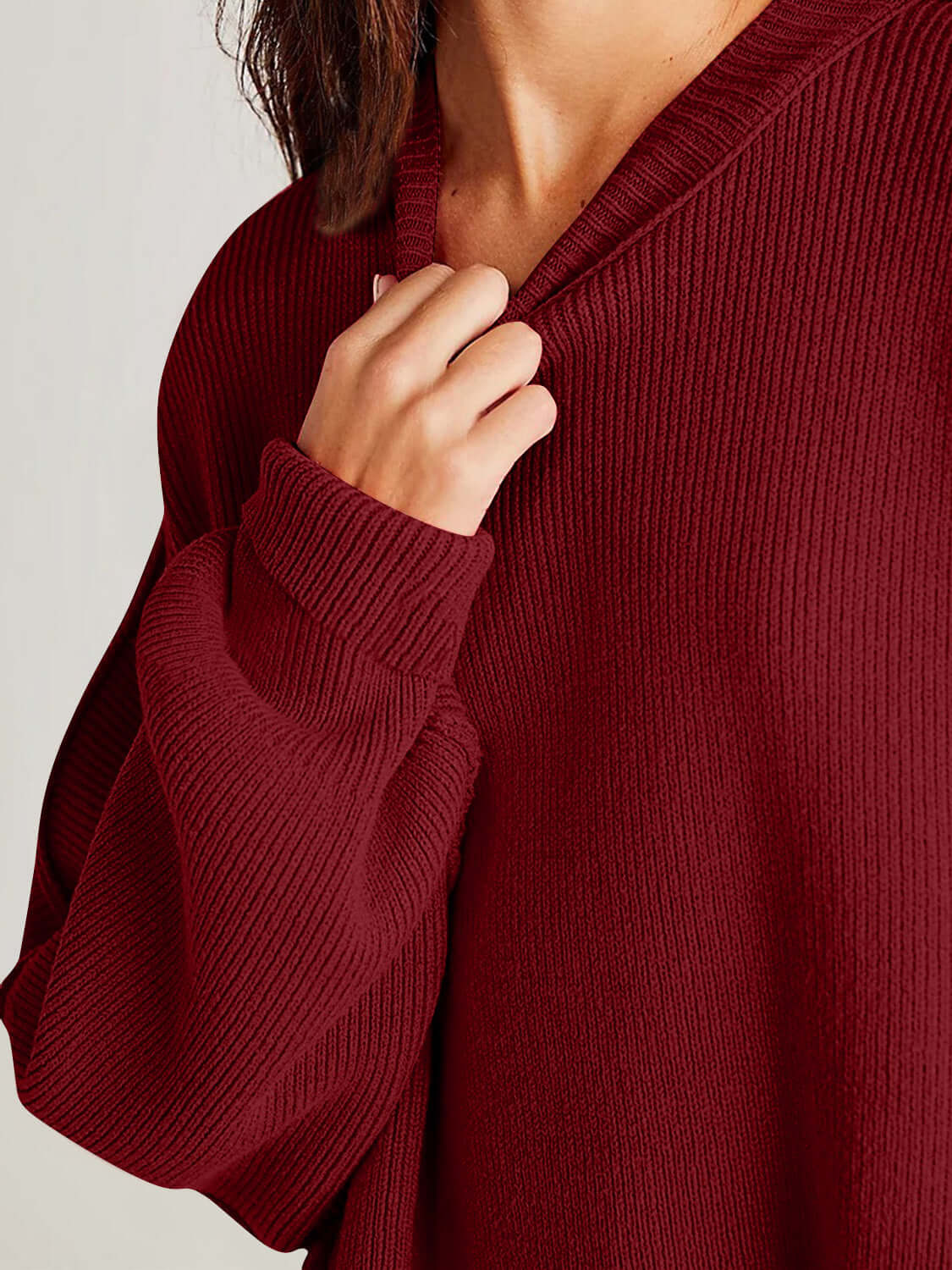 Woman wearing a cozy maroon Double Take Side Slit Round Neck Long Sleeve Sweater with ribbed texture