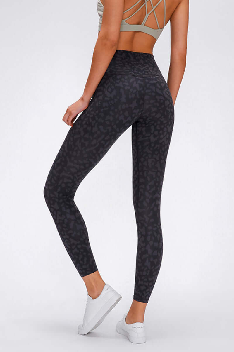 Stylish woman in Millennia wide seamless band waist leggings with a trendy leopard print, perfect for workouts and adventures.