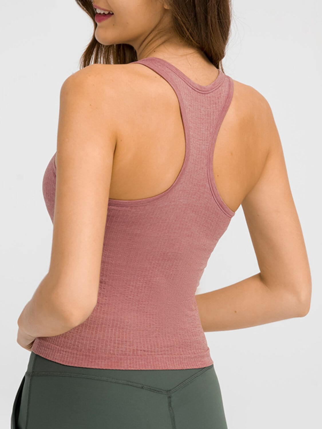 Model showcasing the back of the Millennia Round Neck Racerback Active Tank in rose color, perfect for workouts.