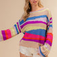 Woman wearing BiBi Multi Color Geometric Stripe Sweater in vibrant knit, showcasing chic modern design perfect for cooler days.