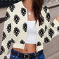 Woman wearing Bella Road Printed Zip Up Long Sleeve Jacket with black playful print, paired with jeans and a white top.