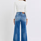 Back view of a model wearing Judy Blue distressed high waist wide leg jeans and a white fitted top.