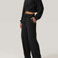 Woman wearing Bella Road Crisscross Round Neck Top and Drawstring Pants Set in black, showcasing a casual and stylish look.