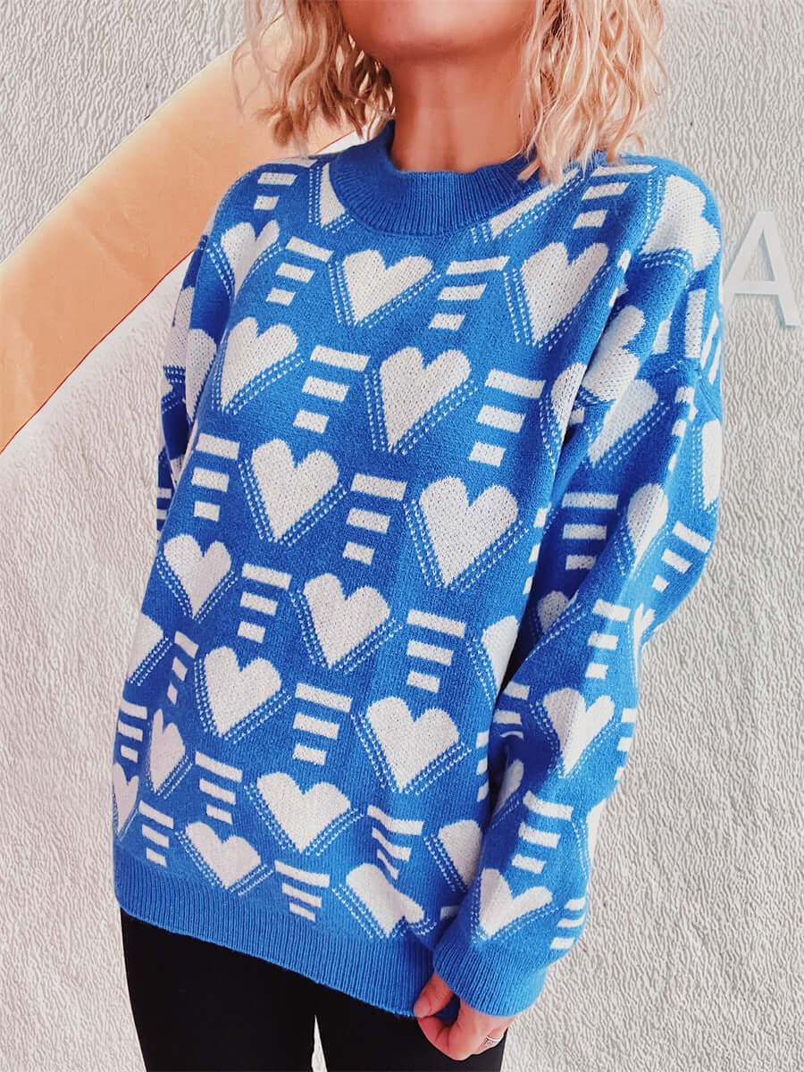 Woman wearing Bella Road Heart Contrast Long Sleeve Dropped Shoulder Sweater in blue with white heart patterns.