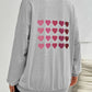 Woman wearing Devine Heart Dropped Shoulder Long Sleeve Sweatshirt with heart prints on the back.