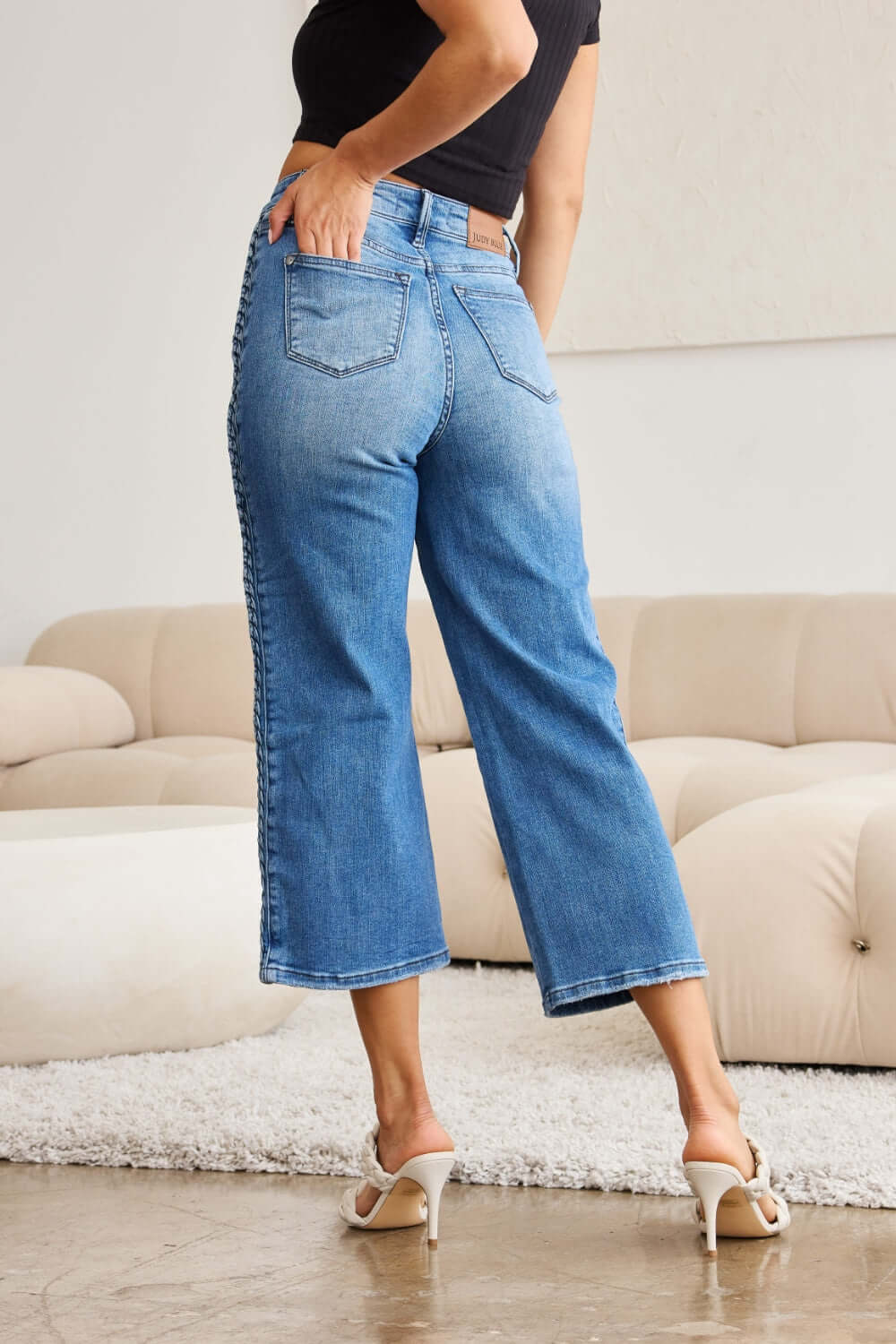 Model wearing Judy Blue braid side detail wide leg jeans showcasing back view and braid detailing with wide leg silhouette