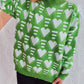 Person wearing Bella Road Heart Contrast Long Sleeve Dropped Shoulder Sweater in green with white heart patterns