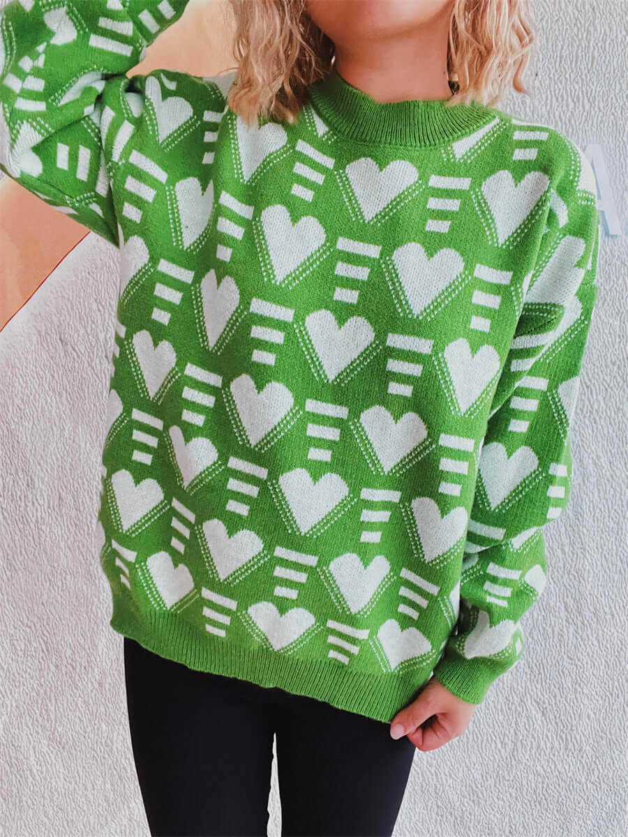 Person wearing Bella Road Heart Contrast Long Sleeve Dropped Shoulder Sweater in green with white heart patterns