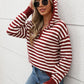 Woman wearing Perfee Striped Long Sleeve Hooded Sweater in burgundy, holding a coffee cup and looking stylish against a white wall.