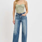 Model wearing RISEN Full Size Distressed Wide Leg Jeans with a light green top, showcasing a relaxed and chic style.