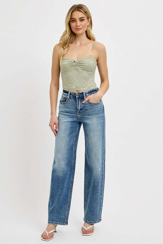 Model wearing RISEN Full Size Distressed Wide Leg Jeans with a light green top, showcasing a relaxed and chic style.