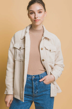 Woman wearing Love Tree Corduroy Button Up Jacket with Sherpa Inside against a beige background, styled casually with jeans.