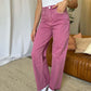 Woman wearing RFM Full Size High Rise Garment Dye Wide Leg Jeans in pink, styled with casual white sneakers and a white top.