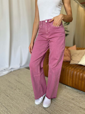 Woman wearing RFM Full Size High Rise Garment Dye Wide Leg Jeans in pink, styled with casual white sneakers and a white top.