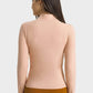 Back view of the Millennia Half Zip Thumbhole Sleeve Sports Top in soft peach, perfect for workouts and yoga sessions.