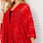 JUSTIN TAYLOR Pom-Pom Asymmetrical Poncho Cardigan in Red at Bella Road