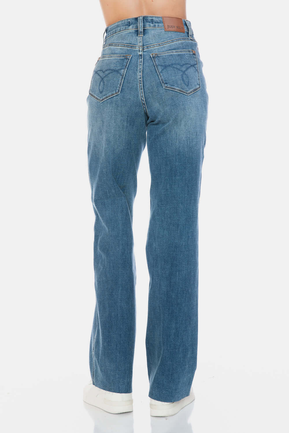 Judy Blue high-waist tummy control jeans with raw hem in blue, back view showcasing stylish silhouette and comfort fit.