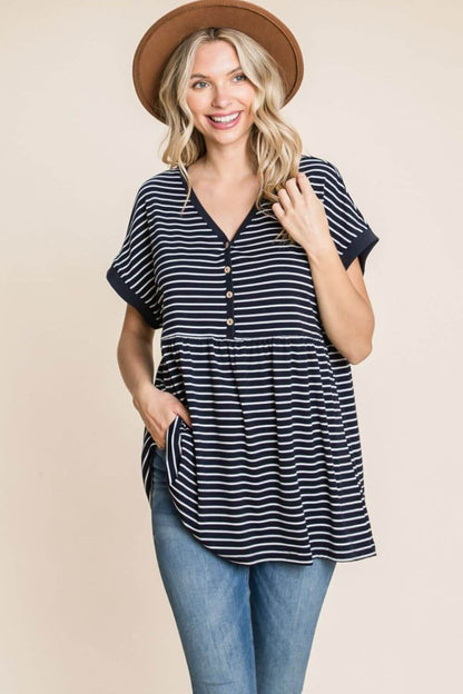 Woman wearing a Striped Button Front Baby Doll Top with a hat, featuring classic stripes, trendy buttons, and a flattering silhouette.