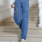 Woman wearing Bella Road High Waist Straight Leg Jeans with Pockets, paired with white sneakers, standing on staircase.